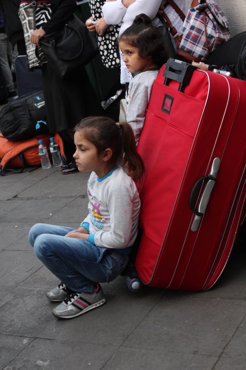 girls by red suitcase